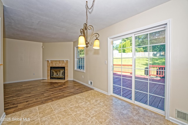 5 Bridgewood Ln, Watervliet, NY 12189 - unfurnished living room with a tile fireplace, a chandelier, and tile patterned flooring
