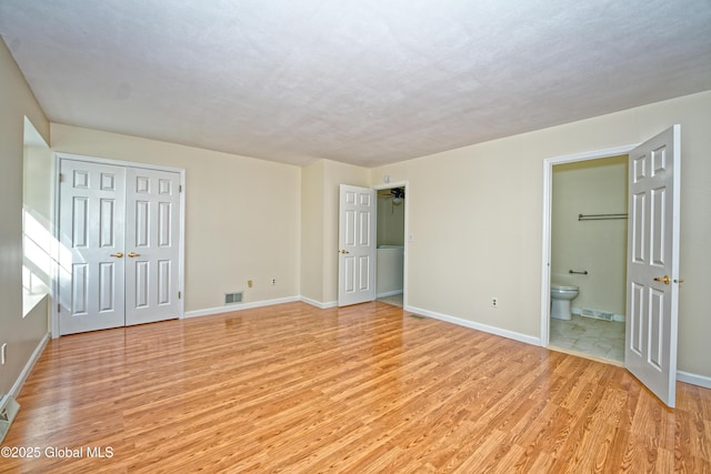 5 Bridgewood Ln, Watervliet, NY 12189 - unfurnished bedroom with light wood-style flooring, ensuite bathroom, and a closet