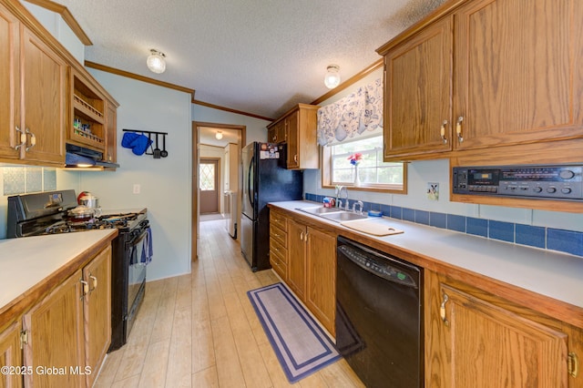 114 Burdick Rd, Johnstown, NY 12078 - kitchen with black appliances, ornamental molding, light countertops, brown cabinets, and under cabinet range hood