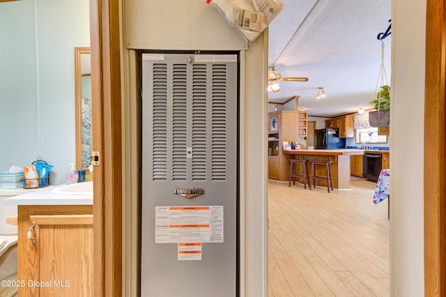 114 Burdick Rd, Johnstown, NY 12078 - detailed view of black appliances, a heating unit, wood finished floors, and a ceiling fan