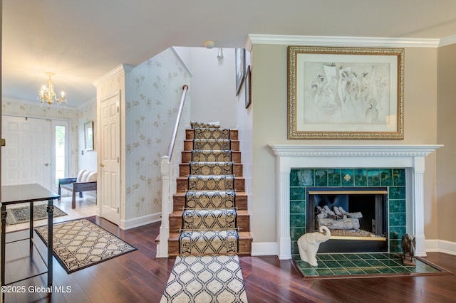 125 Bridgewood Ln, Colonie, NY 12189 - stairs featuring wallpapered walls, crown molding, wood finished floors, a chandelier, and a fireplace