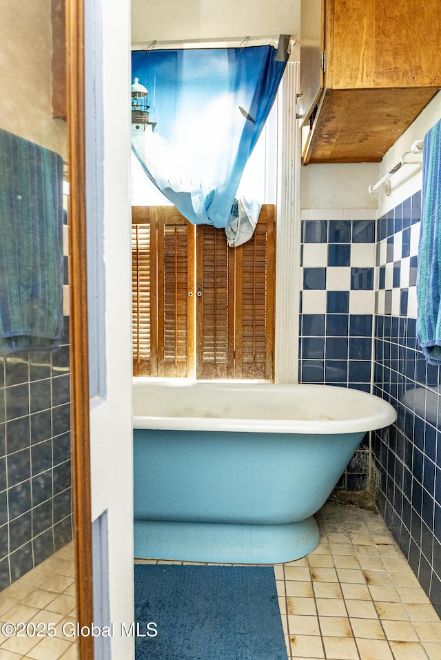 53 Broad St, Catskill, NY 12414 - bathroom with a freestanding bath, tile patterned flooring, and tile walls