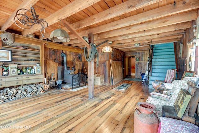 448 State Highway 334, Johnstown, NY 12095 - unfurnished living room featuring wooden walls, a wood stove, wood-type flooring, and a wood ceiling with exposed beams