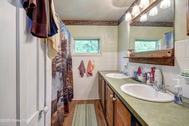 448 State Highway 334, Johnstown, NY 12095 - bathroom featuring tile walls, wood finished floors, double vanity, and wainscoting