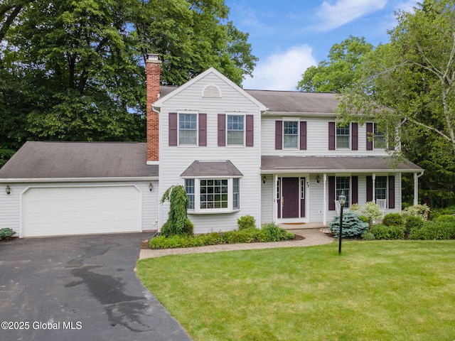 77 Rotterdam Dr, Bethlehem, NY 12077 - view of front of house featuring a chimney, asphalt driveway, a garage, and a front lawn