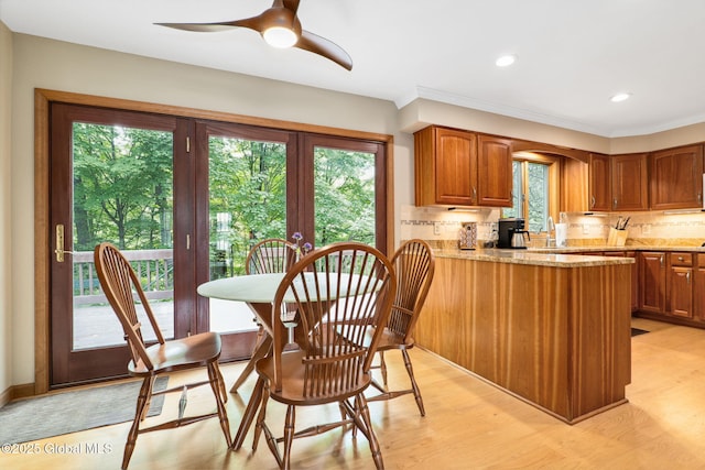 77 Rotterdam Dr, Bethlehem, NY 12077 - kitchen with light stone counters, decorative backsplash, light wood-style flooring, a peninsula, and recessed lighting