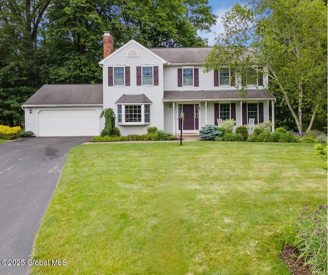 77 Rotterdam Dr, Bethlehem, NY 12077 - view of front of property with asphalt driveway, a chimney, an attached garage, a front yard, and covered porch