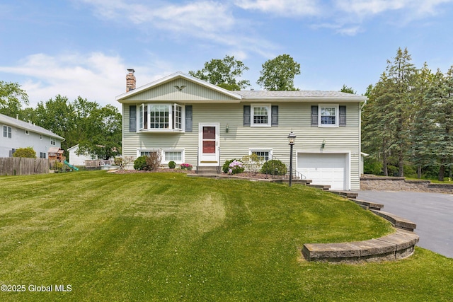 47 Comely Ln, Colonie, NY 12110 - split foyer home featuring a garage, a chimney, asphalt driveway, and a playground