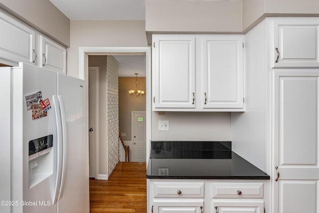 47 Comely Ln, Colonie, NY 12110 - kitchen with white fridge with ice dispenser, dark countertops, white cabinetry, and wood finished floors