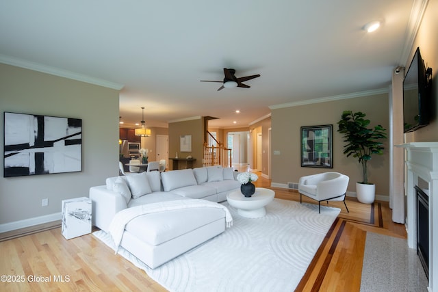 1 Arbor Dr, Guilderland, NY 12159 - living area featuring light wood-type flooring, crown molding, a fireplace, ceiling fan, and recessed lighting