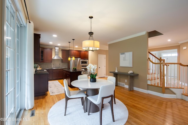 1 Arbor Dr, Guilderland, NY 12159 - dining space featuring light wood-type flooring, crown molding, stairs, and recessed lighting