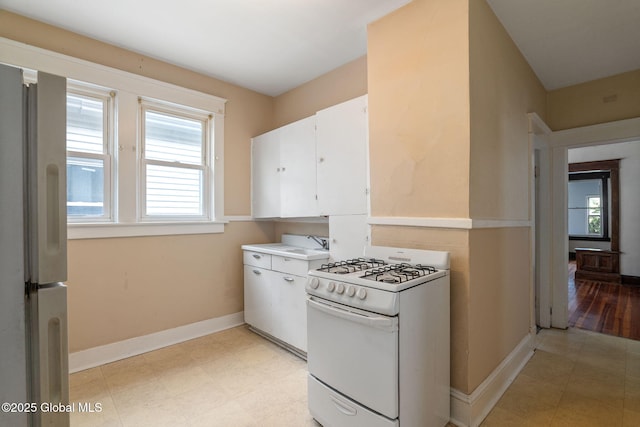 13 Barclay St, Albany, NY 12209 - kitchen with white range with gas cooktop, freestanding refrigerator, white cabinetry, and light countertops