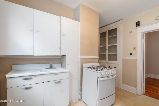 13 Barclay St, Albany, NY 12209 - kitchen featuring white range with gas stovetop, light countertops, glass insert cabinets, and white cabinetry