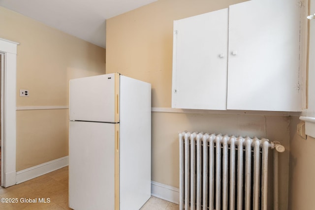 13 Barclay St, Albany, NY 12209 - kitchen with freestanding refrigerator, radiator heating unit, white cabinets, and light tile patterned floors