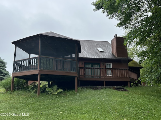 11 Ridgecrest Way, Hampton, NY 12887 - back of house featuring a chimney, a lawn, a sunroom, a shingled roof, and a wooden deck