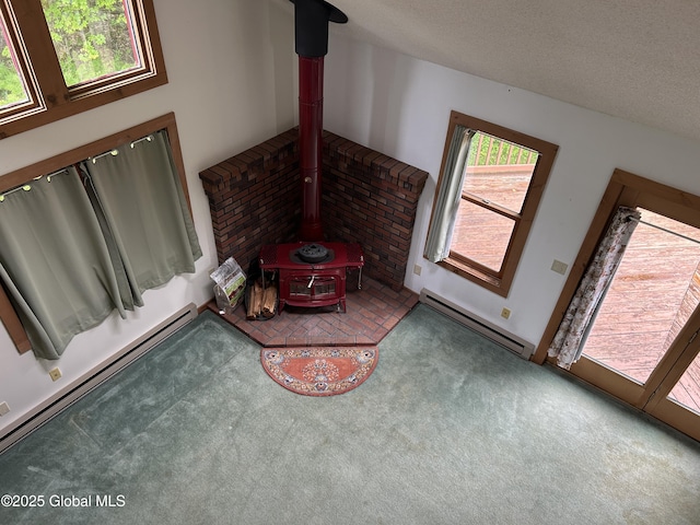 11 Ridgecrest Way, Hampton, NY 12887 - unfurnished living room featuring baseboard heating, a wood stove, and carpet