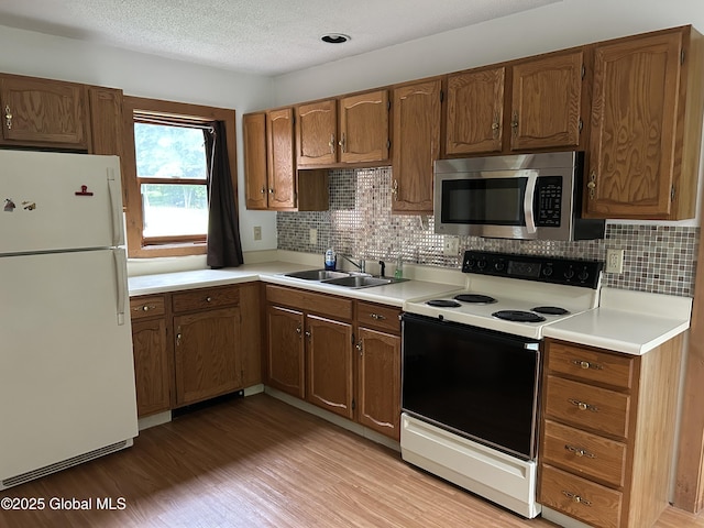 11 Ridgecrest Way, Hampton, NY 12887 - kitchen featuring white appliances, light wood-style flooring, decorative backsplash, light countertops, and a textured ceiling