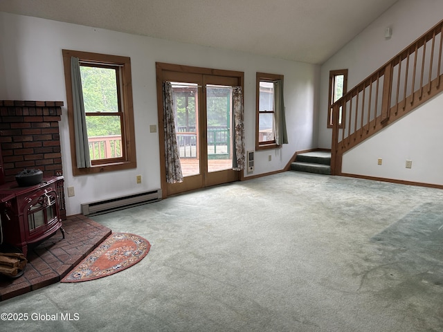 11 Ridgecrest Way, Hampton, NY 12887 - unfurnished living room featuring baseboard heating, a wood stove, carpet, stairs, and lofted ceiling