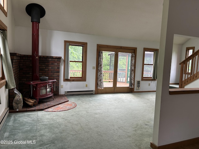 11 Ridgecrest Way, Hampton, NY 12887 - unfurnished living room with baseboard heating, a wood stove, healthy amount of natural light, and carpet flooring