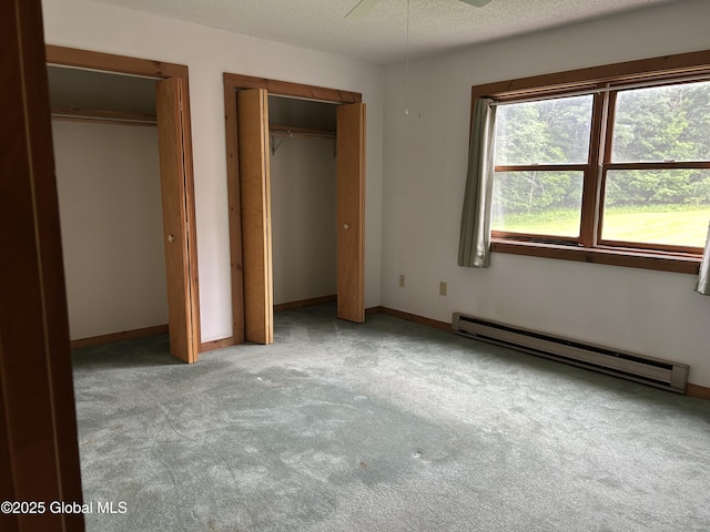 11 Ridgecrest Way, Hampton, NY 12887 - unfurnished bedroom with a baseboard radiator, two closets, carpet, and a textured ceiling