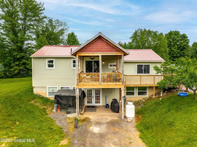 2560 Creek Rd, Esperance, NY 12066 - view of front of house featuring a front lawn, a metal roof, french doors, a patio area, and a wooden deck
