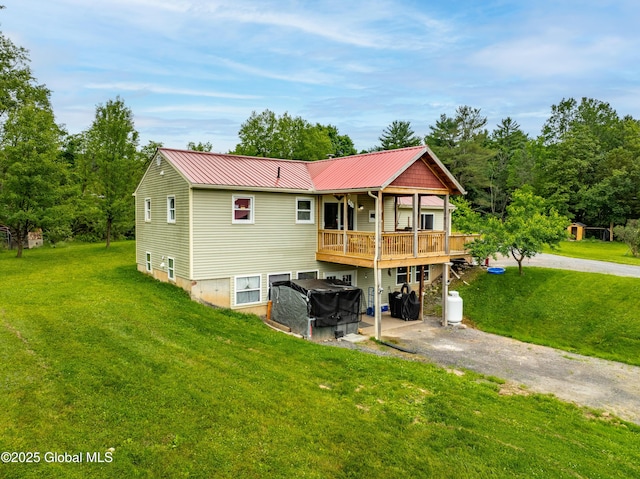 2560 Creek Rd, Esperance, NY 12066 - back of property featuring a lawn, a metal roof, driveway, and a wooden deck