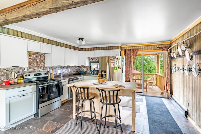 2560 Creek Rd, Esperance, NY 12066 - kitchen with stainless steel appliances, backsplash, white cabinets, a breakfast bar area, and dark stone finish flooring