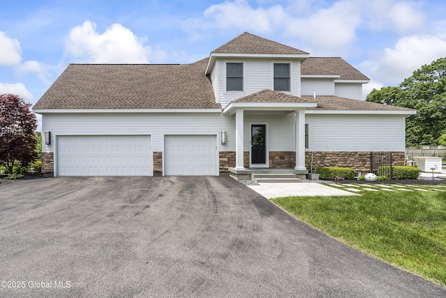 23 Steeple View Dr, Colonie, NY 12211 - view of front of home featuring asphalt driveway, a garage, a shingled roof, stone siding, and a front lawn
