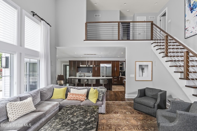 23 Steeple View Dr, Colonie, NY 12211 - living room featuring a high ceiling, dark wood-type flooring, and stairway