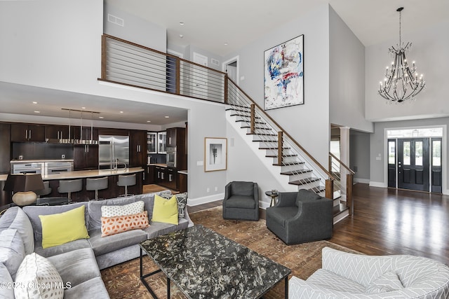 23 Steeple View Dr, Colonie, NY 12211 - living area featuring a high ceiling, stairway, dark wood-type flooring, and a chandelier
