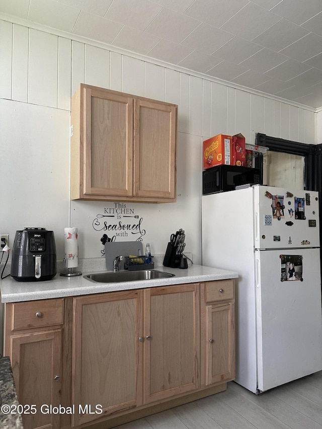 327 E Main St, Amsterdam, NY 12010 - kitchen featuring freestanding refrigerator, light wood-type flooring, light countertops, and light brown cabinetry