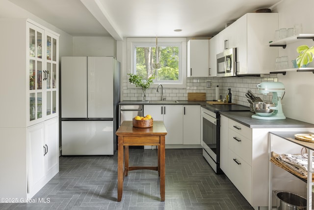 12 Mill St, Chatham, NY 12037 - kitchen with appliances with stainless steel finishes, dark countertops, white cabinets, decorative backsplash, and open shelves