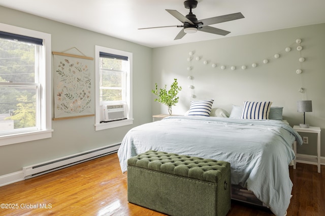 12 Mill St, Chatham, NY 12037 - bedroom with baseboard heating, cooling unit, wood finished floors, and a ceiling fan