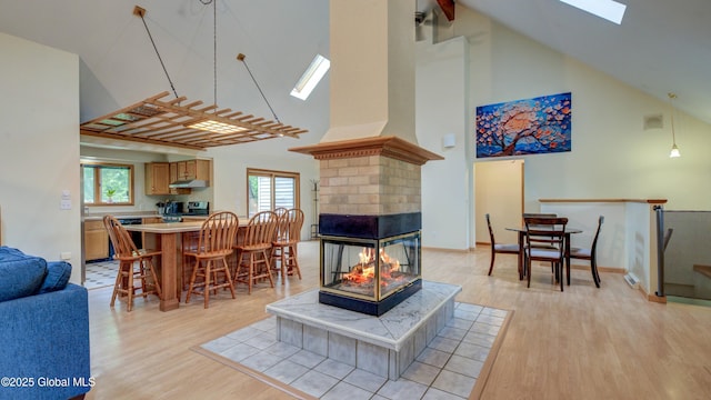 324 Elsmere Ave, Bethlehem, NY 12054 - dining space featuring a skylight, high vaulted ceiling, light wood finished floors, plenty of natural light, and a multi sided fireplace