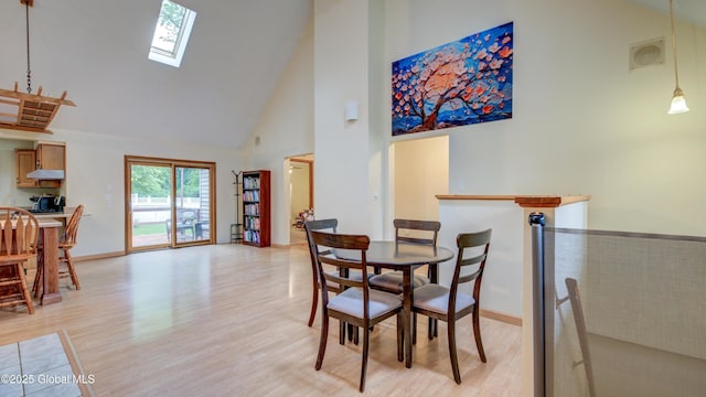 324 Elsmere Ave, Bethlehem, NY 12054 - dining space with high vaulted ceiling, a skylight, and light wood-style flooring