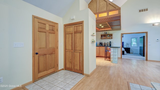 324 Elsmere Ave, Bethlehem, NY 12054 - entryway with high vaulted ceiling, light wood finished floors, and bar