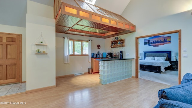 324 Elsmere Ave, Bethlehem, NY 12054 - kitchen featuring light wood-style flooring, dark countertops, a high ceiling, and open floor plan