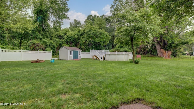 324 Elsmere Ave, Bethlehem, NY 12054 - fenced backyard with a shed, an outdoor pool, a deck, and view of wooded area