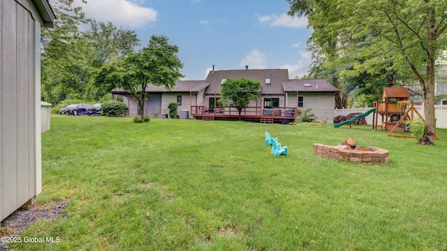 324 Elsmere Ave, Bethlehem, NY 12054 - rear view of house with a playground, a yard, a wooden deck, and an outdoor fire pit
