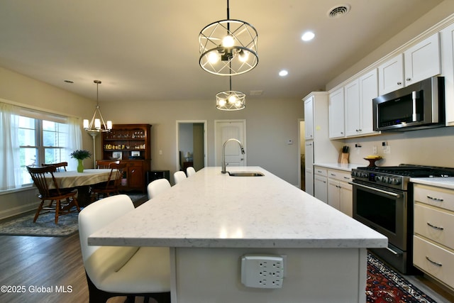 16 Anthony Pl, Ballston, NY 12020 - kitchen featuring stainless steel appliances, a breakfast bar, white cabinets, a kitchen island with sink, and decorative light fixtures