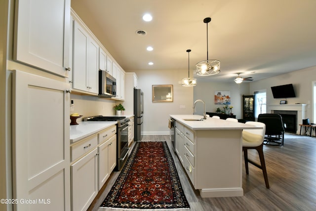 16 Anthony Pl, Ballston, NY 12020 - kitchen featuring appliances with stainless steel finishes, a breakfast bar area, an island with sink, open floor plan, and light countertops