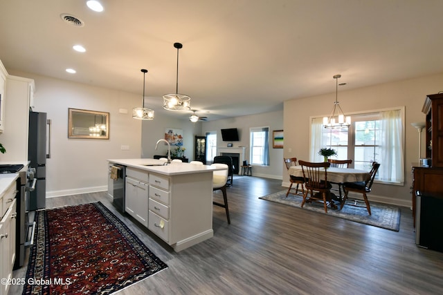 16 Anthony Pl, Ballston, NY 12020 - kitchen featuring stainless steel appliances, a chandelier, a fireplace, light countertops, and white cabinets