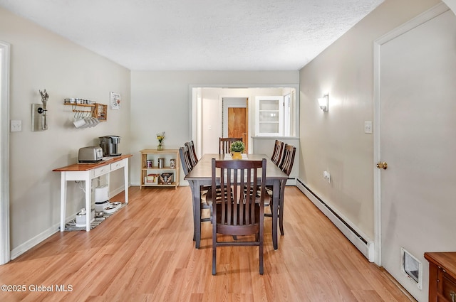 17 Malpass Rd, Guilderland, NY 12203 - dining area with a baseboard heating unit, light wood-style floors, and a textured ceiling