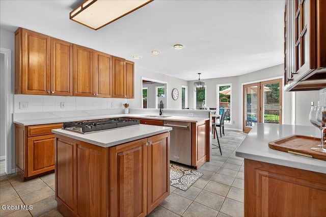1 Fox Run, Colonie, NY 12110 - kitchen with stainless steel dishwasher, cooktop, brown cabinets, light countertops, and a peninsula