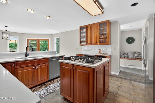 1 Fox Run, Colonie, NY 12110 - kitchen featuring appliances with stainless steel finishes, light countertops, brown cabinetry, glass insert cabinets, and a center island