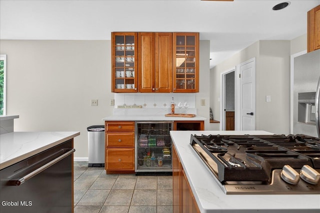 1 Fox Run, Colonie, NY 12110 - kitchen featuring stainless steel appliances, beverage cooler, brown cabinets, backsplash, and light stone countertops