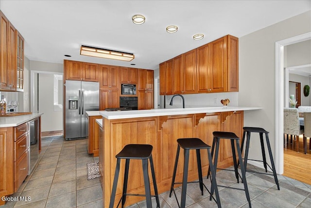 1 Fox Run, Colonie, NY 12110 - kitchen with black microwave, stainless steel refrigerator with ice dispenser, a peninsula, and light tile patterned flooring