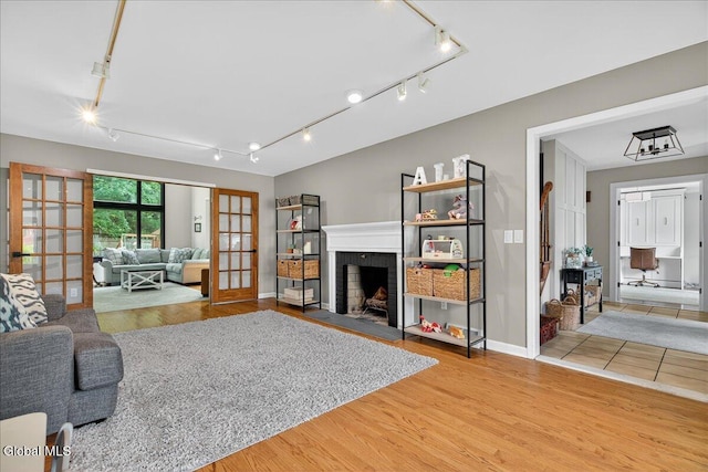1 Fox Run, Colonie, NY 12110 - living room with rail lighting, french doors, a brick fireplace, and light wood-type flooring