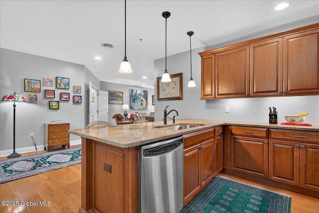 70 Railroad Pl Unit 207, Saratoga Springs, NY 12866 - kitchen with stainless steel dishwasher, brown cabinetry, light wood-type flooring, a peninsula, and recessed lighting