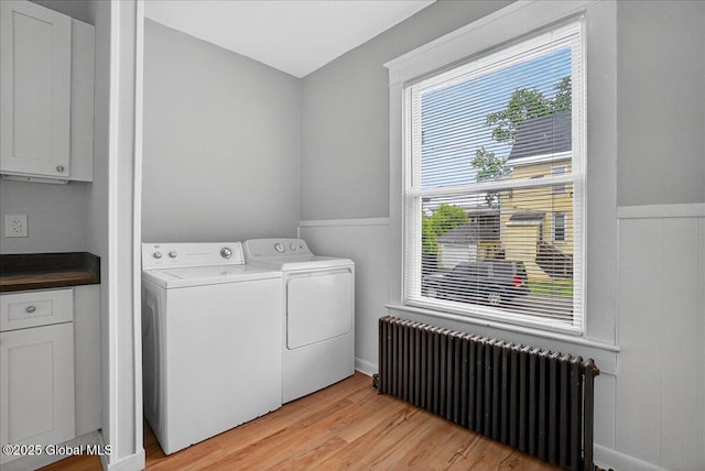 329 E Main St, Amsterdam, NY 12010 - laundry room featuring radiator heating unit, washing machine and clothes dryer, and light wood-style flooring